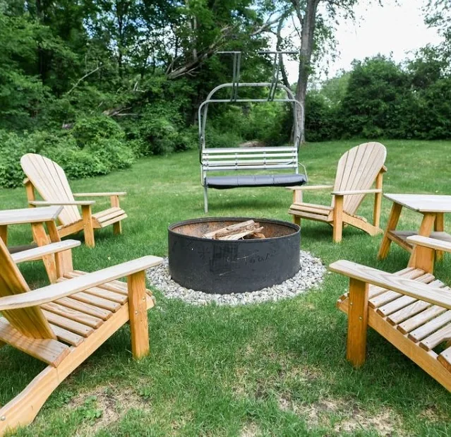 Fire pit circle with Adirondack chairs and ski-lift bench