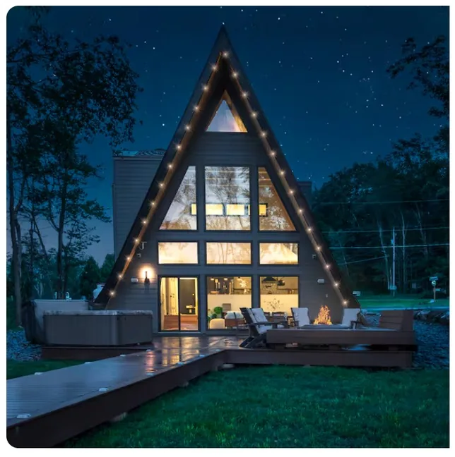 A-frame exterior at night with string lights