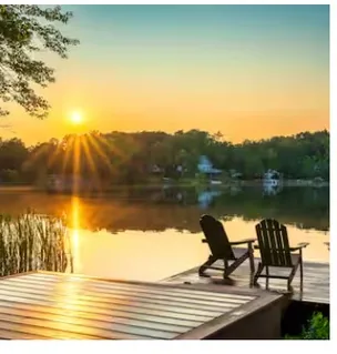 Lakeside dock with Adirondack chairs at sunset