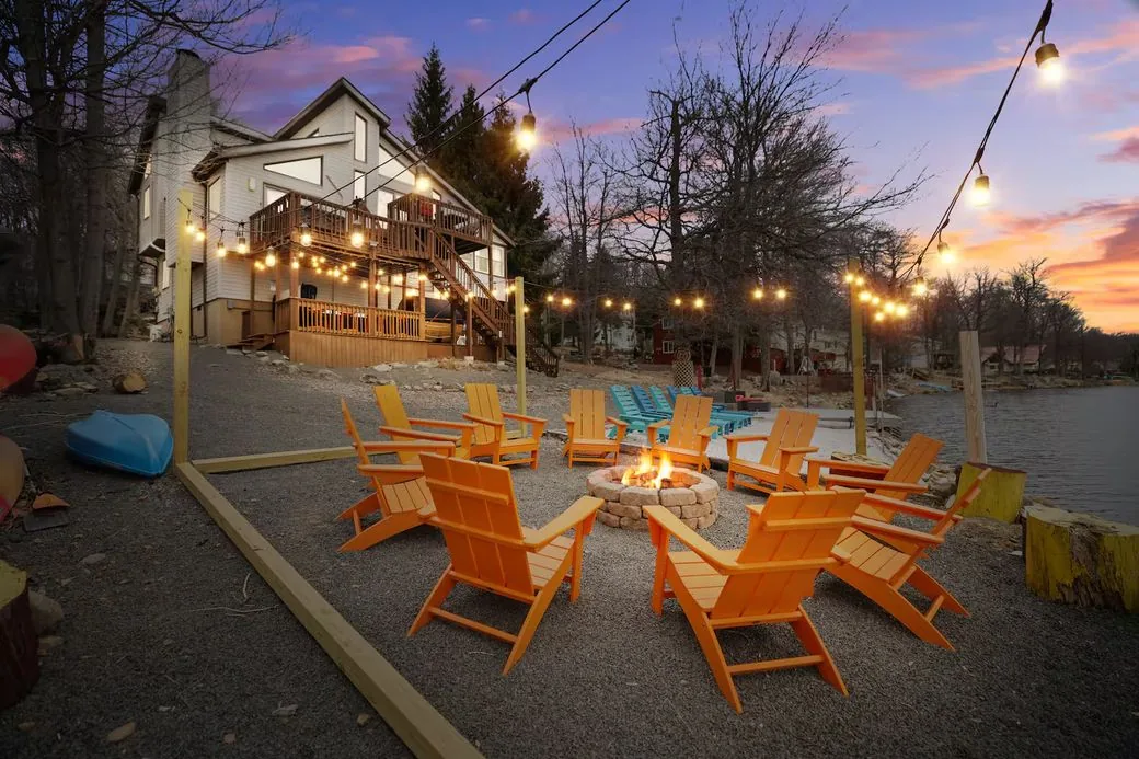 Fire pit circle under string lights at dusk